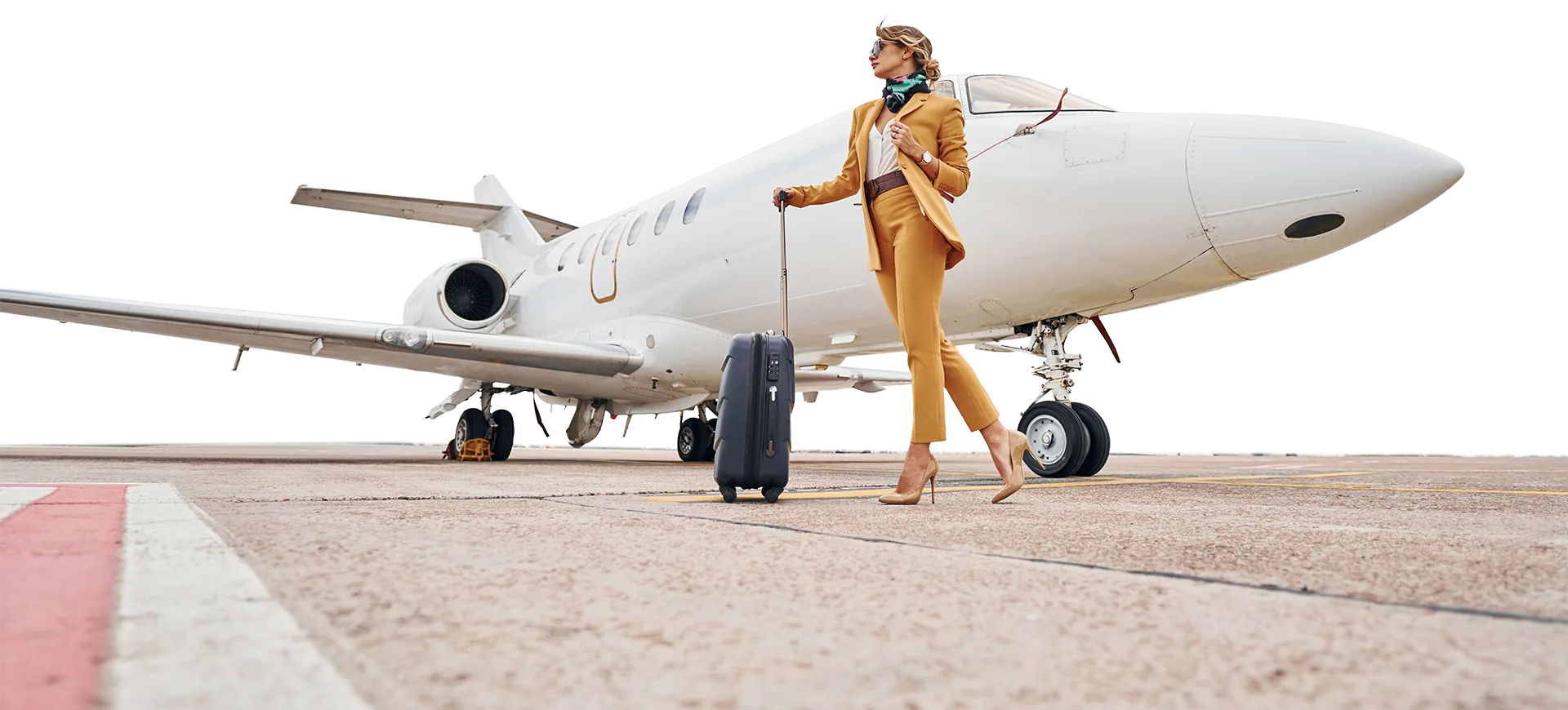 Traveler with luggage walking past a private jet on the tarmac